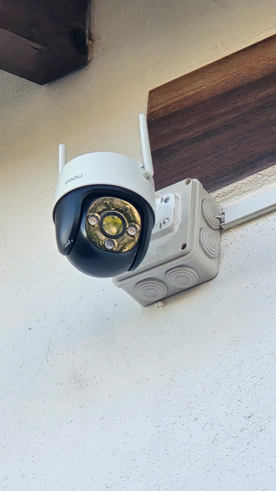Cámara domo PTZ IMOU instalada en esquina exterior de casa